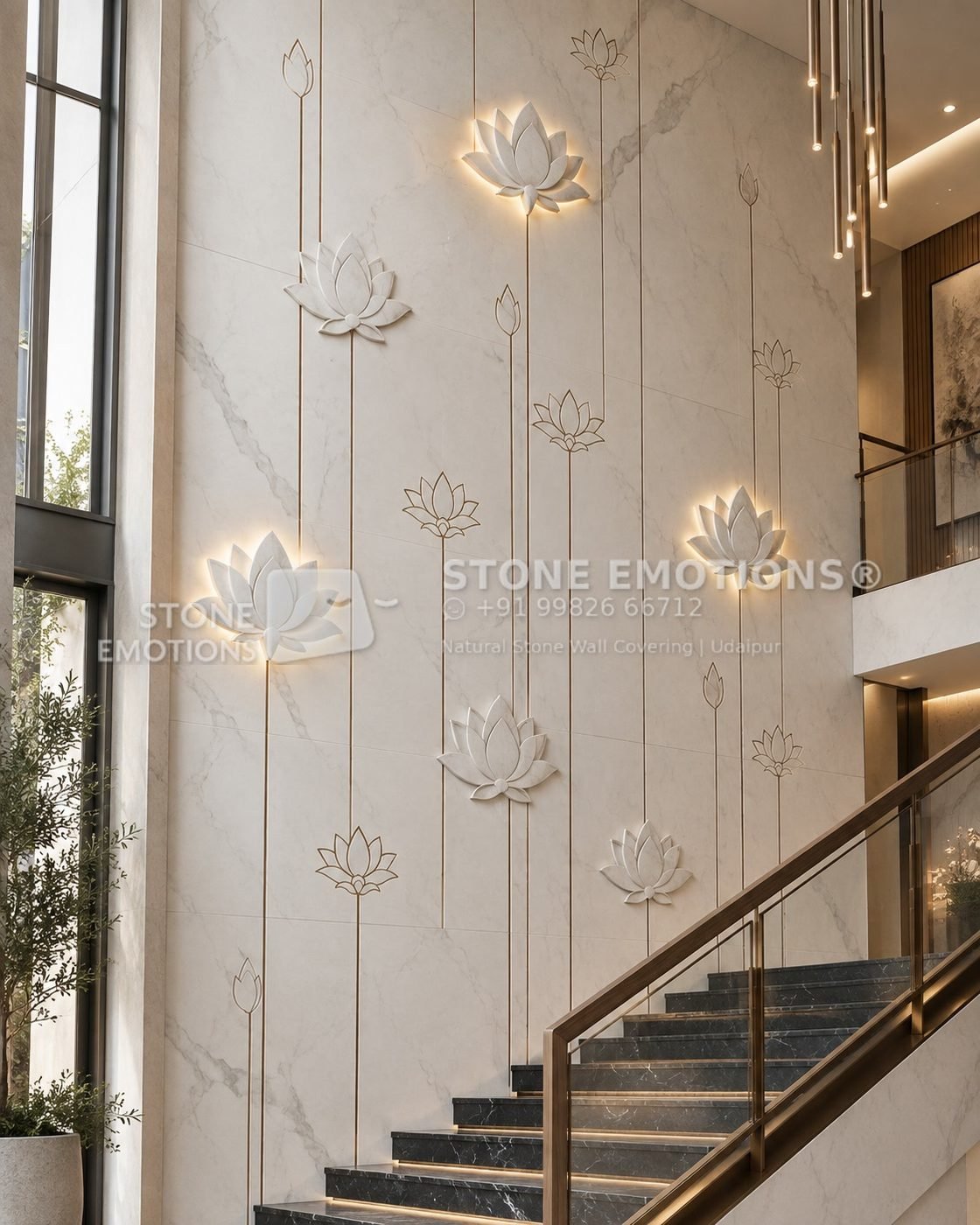 Double-height natural stone staircase wall with tall lotus stems and backlit carved lotus flowers