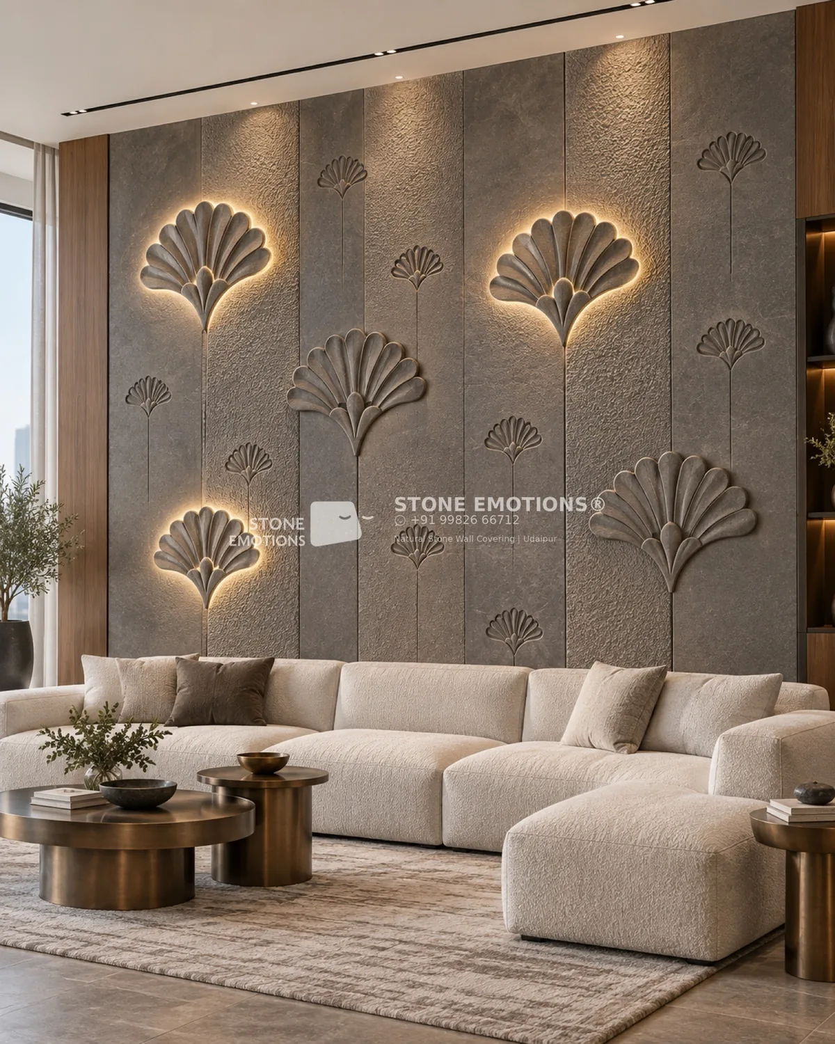 Ginkgo leaf CNC stone feature wall behind a living room sofa: grey textured natural stone vertical panels with 3D relief ginkgo leaves, some backlit with a warm halo, and engraved ginkgo outlines