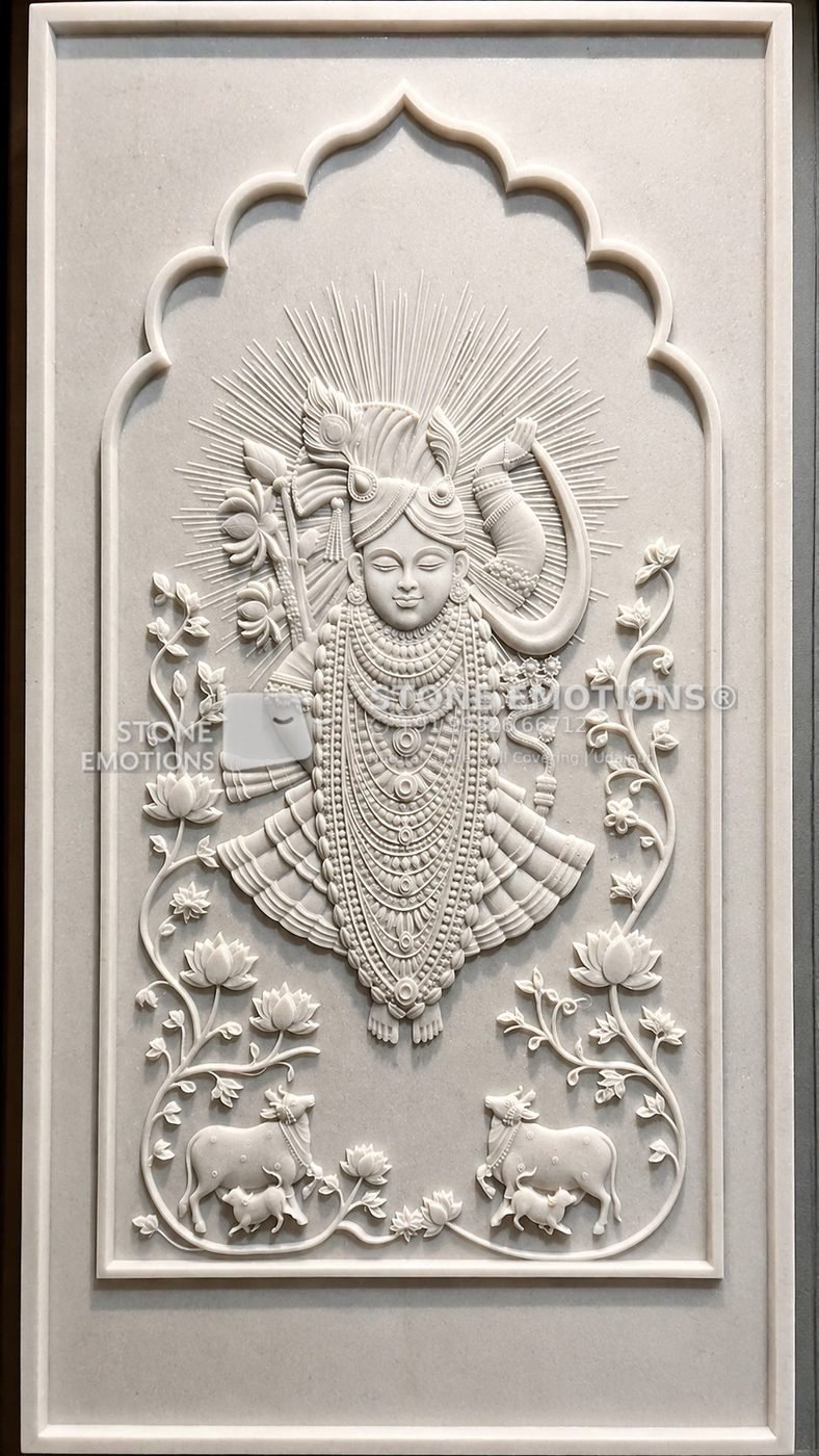 White natural stone pooja panel with a Shrinathji relief inside a cusped arch, with lotus and cows at the base